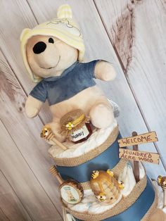 a large teddy bear sitting on top of a blue and white hat with honey in it's mouth