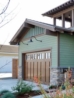 a green house with a brown garage door