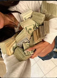 a woman holding stacks of money in her hands