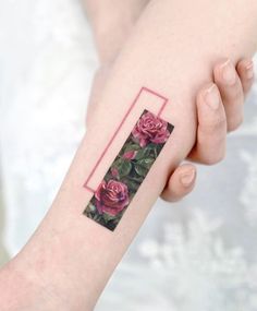 a woman's arm with pink roses on it and a rectangle in the middle