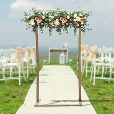 an outdoor ceremony setup with white chairs and flowers