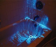 a bathtub that has some blue lights on the side and water running down it