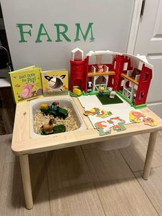 a play table with farm animals and toys on it in front of a sign that says farm