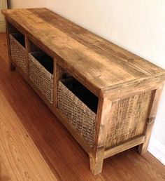 a wooden bench with two baskets on it's sides next to a white wall