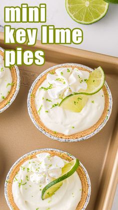 mini key lime pies on a baking sheet with lime slices and whipped cream in the middle