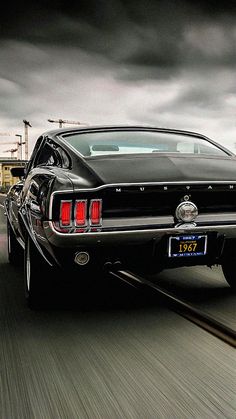 a car driving down the road with dark clouds in the back ground and on top of it