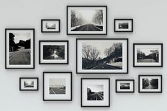 black and white photographs hanging on the wall in front of a gray wall with multiple frames