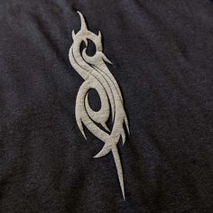 a close up of a black shirt with a white dragon on it's chest