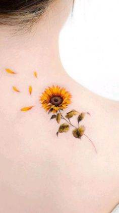 a sunflower tattoo on the back of a woman's neck, with yellow petals