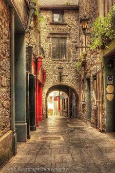 an alley way with stone buildings and red doors