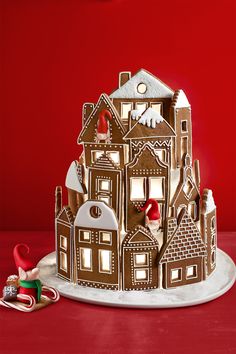 a gingerbread house is decorated with icing and candy canes on a platter