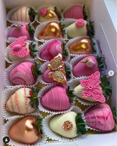 a box filled with pink and white chocolates covered in gold leafy decorations on top of each other