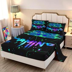 a bed with black and green paint splattered on the sheets, along with two nightstands