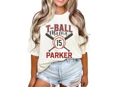 Elevate your game day look with our custom "T-Ball Mom" shirt, personalized with the player's name and the year. This crewneck tshirt is the perfect baseball gift for moms, offering both style and sentimentality for those memorable moments at the ballpark. COMFORT COLORS 1717 SHIRT: Unisex 100% US cotton - ethically grown and harvested Pre-Shrunk Fabric Relaxed Fit - Size up for a trendy oversized look Seamless Sides Double Needle Stitching Garment-dyed  CARE INSTRUCTIONS: Wash inside out with c T Ball Shirts, Collegiate T-shirt With Custom Print For Game Day, Varsity T-shirt With Custom Print For Game Day, Varsity Cotton T-shirt With Custom Print, Customizable White T-shirt For Baseball Season, Customizable Crew Neck T-shirt For Game Day, Customizable Cotton T-shirt For Game Day, Customizable White Fan Apparel T-shirt, Varsity Sublimation Short Sleeve Fan Gear