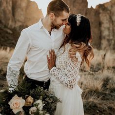 a man and woman standing next to each other in the desert