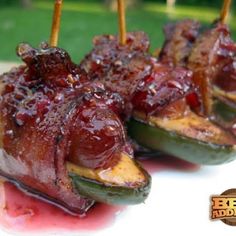 bacon wrapped jalapenos are sitting on a plate with toothpicks sticking out of them