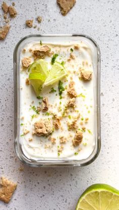 a container filled with ice cream next to a lime slice and crackers on the side