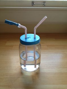 a glass jar with two straws in it