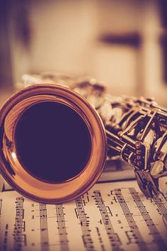 a saxophone and music sheet with musical notes in the foreground, close up view