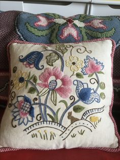 a decorative pillow with flowers and birds on it