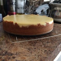 a cheesecake sitting on top of a counter next to an oven and other food items