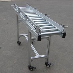 a metal conveyor belt sitting on top of a parking lot