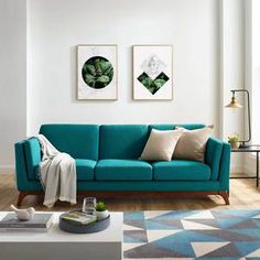 a living room with blue couches and two pictures on the wall above each couch