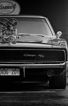 a black and white photo of an old muscle car with the hood on it's headlight