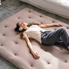 a woman is laying on an inflatable mattress with headphones around her ears