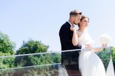 a bride and groom standing on a balcony