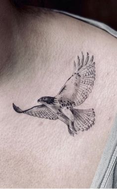 a bird tattoo on the back of a woman's neck is shown in black and white