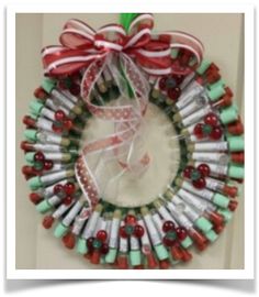 a wreath made out of wine bottles with a green ribbon hanging from the front door