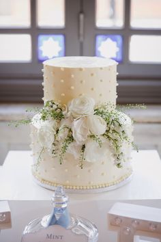 a wedding cake with white flowers and greenery