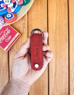 a hand holding a red leather key chain