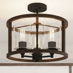 a light fixture with three glass shades hanging from the ceiling