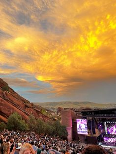 an outdoor concert with people watching the sun set