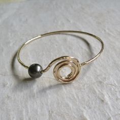 "Gold Spiral Bangle~ Beautiful gold spiral bangle, custom made for you, hammered and polished for that extra sparkle! The Spiral is a sacred symbol that represents the journey and change of life as it unfolds; taking a labyrinth-like passage that leads to Source. The spiral symbol can represent the consciousness of nature beginning from its center expanding outwardly. *Chose from 14 gauge or thicker 12 gauge from the drop down menu, also you can add a Tahitian pearl or white freshwater pearl. ** Gold Spiral Wire Wrapped Bracelets, Elegant Wire Wrapped Spiral Bracelets, Elegant Spiral Wire Wrapped Bracelets, Elegant Spiral Wire Wrapped Bracelet, Adjustable Spiral Gold Bangle, Adjustable Gold Spiral Bangle, Gold Spiral Bracelet As Gift, Gold Spiral Bracelet For Gift, Change Of Life