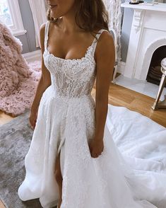 a woman in a white wedding dress standing on a rug