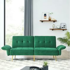 a green couch sitting on top of a white rug in a living room next to a window