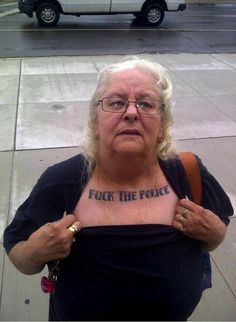 an older woman with glasses on her face is standing in front of a police car