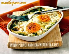 an egg casserole with spinach and cheese in a white dish on a wooden cutting board