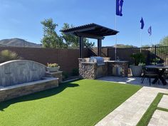 an outdoor kitchen and grill area with artificial grass