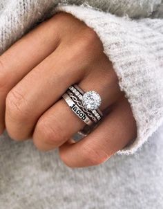 a woman's hand wearing a ring with the word love on it and a diamond