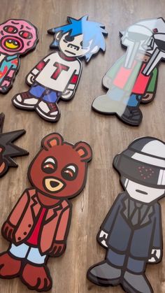 several cut outs of cartoon characters on a wooden floor