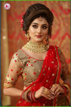 a woman in a red and gold sari with jewelry on her neck, wearing an elaborate