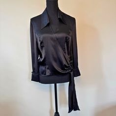 Excellent Pre-Owned Condition Indulge In Sophisticated Style With This Escada Black Wrap-Around Blouse. Designed In Luxurious 100% Silk, It Features A Classic Wrap-Around Enclosure, A Chic Collar, And A Flattering V-Neck. The Crystal Button Cuffs Add A Touch Of Refined Glamour, Making This Size 8 Blouse A Perfect Choice For Both Elegant And Professional Settings. Elevate Your Wardrobe With This Timeless Piece That Exudes Effortless Luxury. Features Size: Us 8 / Euro 40 Style: Mature Lightweight Designer Fitted Evening Blouse, Designer Long Sleeve Blouse For Night Out, Sleek Long Sleeve Evening Blouse, Sleek Long Sleeve Blouse For Evening, Fitted Tops With Button Cuffs For Night Out, Designer Black Collared Blouse, Black Evening Blouse With Button Cuffs, Elegant Collared Blouse For Formal Occasions, Evening Collared Top With Button Cuffs