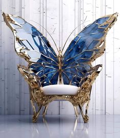 a blue and gold butterfly sculpture sitting on top of a white chair next to a wall