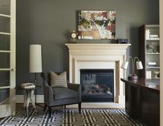 a living room filled with furniture and a fire place next to a desk on top of a hard wood floor