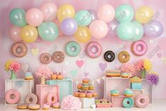 an assortment of doughnuts and donuts on display in front of a balloon wall