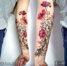 two people holding hands with tattoos on their arms and flowers tattooed on the forearms